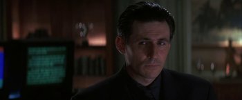 Movie still from “Point of No Return” (1993), directed by John Badham – A person wearing a suit and tie; Close Up shot, Low angle