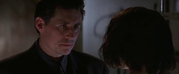 Movie still from “Point of No Return” (1993), directed by John Badham – A person wearing a suit and a tie; Close Up shot, Over the shoulder angle