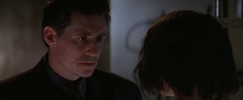Movie still from “Point of No Return” (1993), directed by John Badham – A person sitting next to another person; Close Up shot, Over the shoulder angle