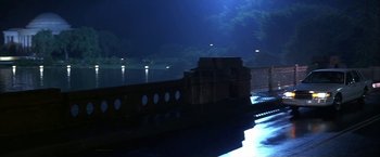 Movie still from “Point of No Return” (1993), directed by John Badham – A night scene of a bridge and a body of water; Extreme Wide shot, Low angle