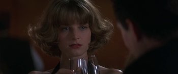 Movie still from “Point of No Return” (1993), directed by John Badham – A person holding a wine glass; Close Up shot, Over the shoulder angle