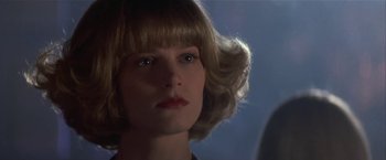 Movie still from “Point of No Return” (1993), directed by John Badham – A person wearing a wig and looking at the camera; Close Up shot, Low angle