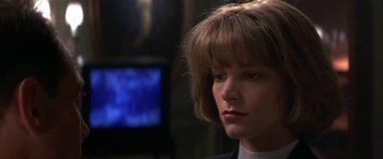 Movie still from “Point of No Return” (1993), directed by John Badham – A person wearing a suit; Close Up shot, Low angle