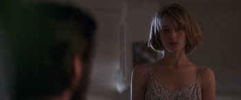Movie still from “Point of No Return” (1993), directed by John Badham – A woman standing in front of a mirror in a room; Close Up shot, Over the shoulder angle