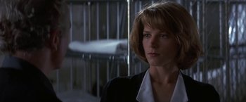 Movie still from “Point of No Return” (1993), directed by John Badham – A person wearing a suit and tie; Close Up shot, Low angle
