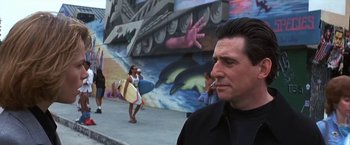 Movie still from “Point of No Return” (1993), directed by John Badham – A man smoking a cigarette in front of a mural; Close Up shot, Low angle