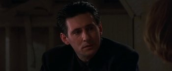 Movie still from “Point of No Return” (1993), directed by John Badham – A person wearing a suit and tie; Close Up shot, Low angle