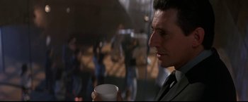 Movie still from “Point of No Return” (1993), directed by John Badham – A person holding a cup of coffee; Close Up shot, Low angle