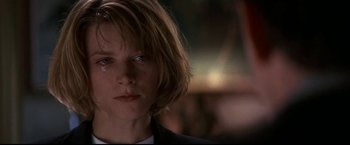 Movie still from “Point of No Return” (1993), directed by John Badham – A person wearing a suit and tie; Close Up shot, Low angle