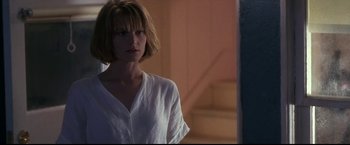 Movie still from “Point of No Return” (1993), directed by John Badham – A woman with short hair is standing in front of a mirror; Medium shot, Low angle