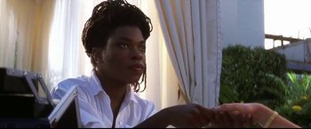 Movie still from “Point of No Return” (1993), directed by John Badham – A woman with dreadlocks sitting in front of a window; Close Up shot, Low angle