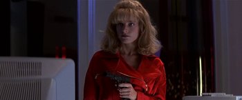 Movie still from “Point of No Return” (1993), directed by John Badham – A woman in a red shirt holding a gun; Close Up shot, Low angle