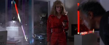 Movie still from “Point of No Return” (1993), directed by John Badham – A woman holding a gun while standing in a room; Medium shot, Low angle
