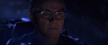 Movie still from “Point of No Return” (1993), directed by John Badham – A person wearing glasses; Close Up shot, Low angle