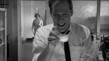 Movie still from “Poison” (1991), directed by Todd Haynes – A black and white photo of a man holding a cup of coffee; Close Up shot, Low angle