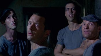Movie still from “Poison” (1991), directed by Todd Haynes – Two men standing next to each other in the dark; Close Up shot, Low angle