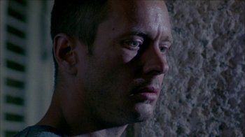 Movie still from “Poison” (1991), directed by Todd Haynes – A man's face in a dark room; Close Up shot, Low angle