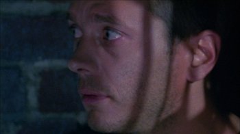 Movie still from “Poison” (1991), directed by Todd Haynes – A man's face with a brick wall in the background; Extreme Close Up shot, Low angle