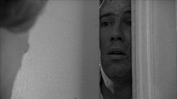 Movie still from “Poison” (1991), directed by Todd Haynes – A black and white photo of a man looking out a window; Close Up shot, Low angle
