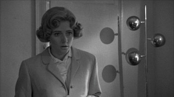 Movie still from “Poison” (1991), directed by Todd Haynes – A black and white photo of a woman in a suit; Medium shot, Over the shoulder angle