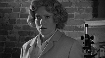 Movie still from “Poison” (1991), directed by Todd Haynes – A black and white photo of a woman in a suit; Close Up shot, Over the shoulder angle
