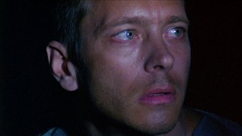 Movie still from “Poison” (1991), directed by Todd Haynes – A man's face in the dark; Close Up shot, High angle