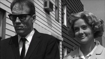 Movie still from “Poison” (1991), directed by Todd Haynes – An older man and a younger woman standing next to each other; Close Up shot, Low angle