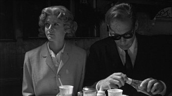 Movie still from “Poison” (1991), directed by Todd Haynes – A man and a woman sitting at a table; Medium shot, Low angle