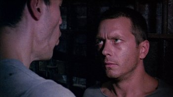 Movie still from “Poison” (1991), directed by Todd Haynes – Two men standing next to each other in front of a brick wall; Close Up shot, Over the shoulder angle