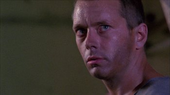 Movie still from “Poison” (1991), directed by Todd Haynes – A man's face in a dark room; Close Up shot, Low angle