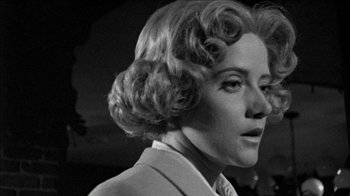 Movie still from “Poison” (1991), directed by Todd Haynes – A black and white photo of a woman in a suit; Close Up shot, Low angle