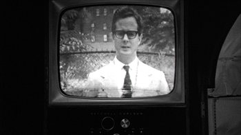 Movie still from “Poison” (1991), directed by Todd Haynes – A black and white photo of a man on a television screen; Close Up shot, Over the shoulder angle