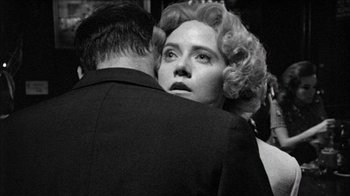 Movie still from “Poison” (1991), directed by Todd Haynes – A man and a woman embracing each other in a black and white photo; Close Up shot, Over the shoulder angle