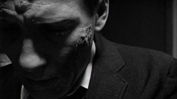 Movie still from “Poison” (1991), directed by Todd Haynes – A person wearing a suit and tie; Extreme Close Up shot, High angle