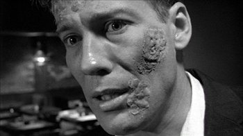 Movie still from “Poison” (1991), directed by Todd Haynes – A black and white photo of a man with dirt all over his face; Close Up shot, Over the shoulder angle