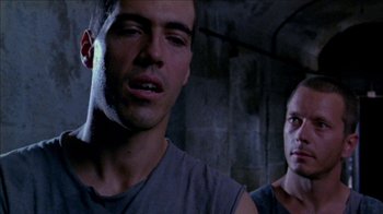Movie still from “Poison” (1991), directed by Todd Haynes – Two men are standing next to each other in a room; Close Up shot, Low angle