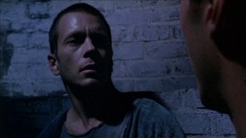 Movie still from “Poison” (1991), directed by Todd Haynes – A person looking at the camera; Close Up shot, Over the shoulder angle
