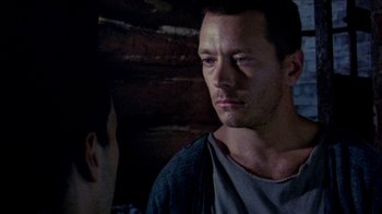 Movie still from “Poison” (1991), directed by Todd Haynes – A man standing next to another man in front of a wooden wall; Close Up shot, Over the shoulder angle