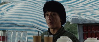 Movie still from “Police Story” (1985), directed by Jackie Chan – A man in a hat is holding two cups of coffee; Close Up shot, High angle