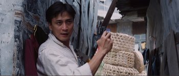 Movie still from “Police Story” (1985), directed by Jackie Chan – A man holding a knife in his hand; Close Up shot, Low angle