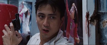 Movie still from “Police Story” (1985), directed by Jackie Chan – A man's face in front of an image of a child; Close Up shot, Low angle