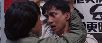 Movie still from “Police Story” (1985), directed by Jackie Chan – Two men are facing each other and one has his mouth wide open; Close Up shot, Low angle