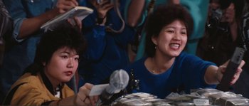 Movie still from “Police Story” (1985), directed by Jackie Chan – A group of people sitting at a table with plates; Close Up shot, Low angle