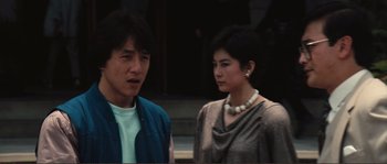 Movie still from “Police Story” (1985), directed by Jackie Chan – A man and a woman standing next to each other on the street; Close Up shot, Over the shoulder angle
