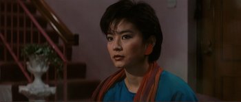 Movie still from “Police Story” (1985), directed by Jackie Chan – A person wearing a blue shirt; Close Up shot, High angle