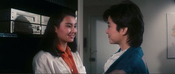 Movie still from “Police Story” (1985), directed by Jackie Chan – Two people are talking to each other in a room; Close Up shot, Over the shoulder angle