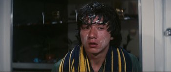 Movie still from “Police Story” (1985), directed by Jackie Chan – A man with a scarf around his face; Close Up shot, High angle
