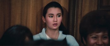 Movie still from “Police Story” (1985), directed by Jackie Chan – A young woman is looking into the camera; Close Up shot, High angle