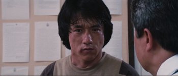 Movie still from “Police Story” (1985), directed by Jackie Chan – A person with long black hair; Close Up shot, Low angle