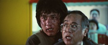 Movie still from “Police Story” (1985), directed by Jackie Chan – A man and a woman are looking at the camera; Close Up shot, Low angle